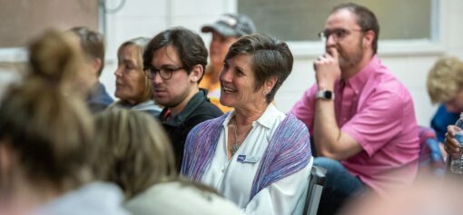 Group of adults sit listening to a speaker