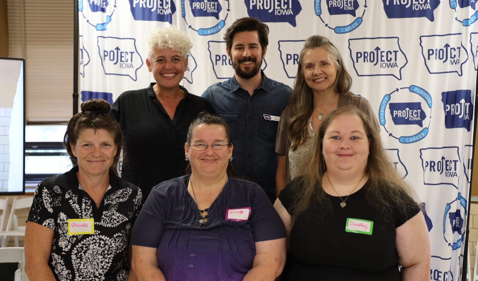 Group of people on stage posing for a photo