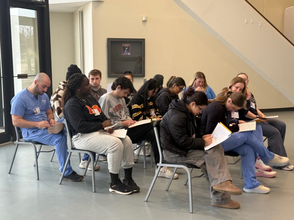 Group of people sitting filling out paper work